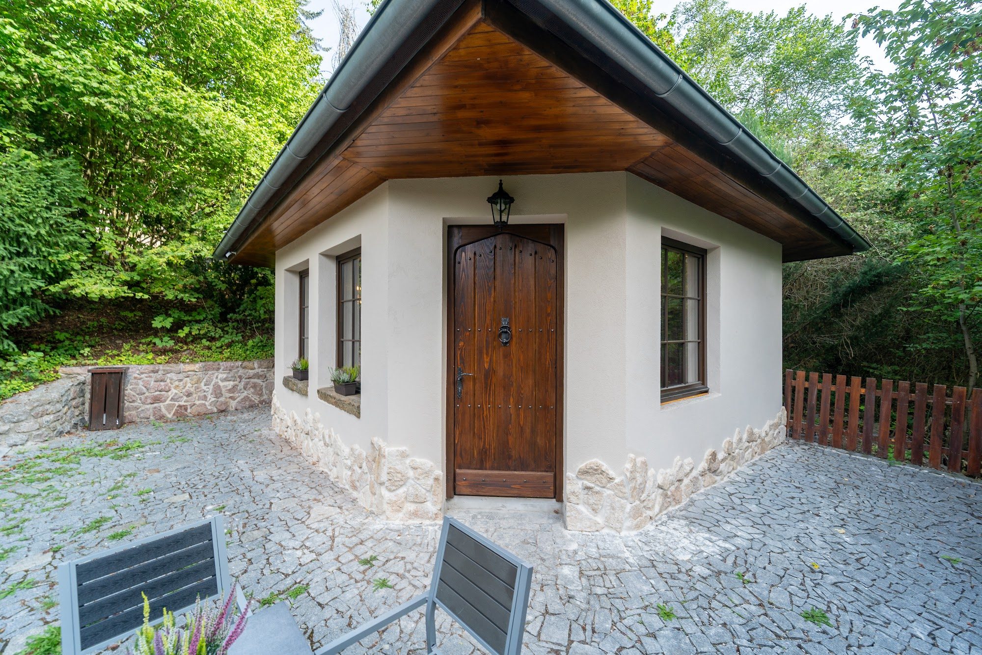 Exteriér chalupy s oploceným posezením
